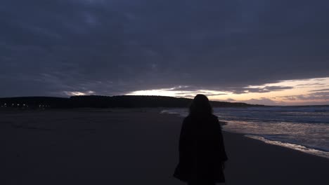 woman walking sunset beach