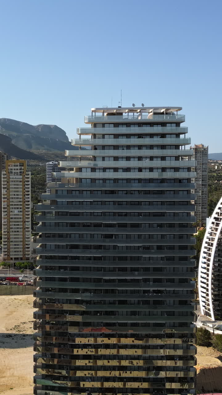 Vista aérea de drone dos edifícios ao longo da costa em Benidorm, Espanha, durante o dia. Vertical