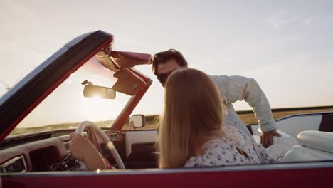 tracking video of happy man jump in red convertible