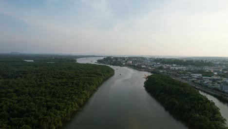 Aerial-drone-panning-up-over-an-island-in-the-middle-of-a-river-and-mangrove-forest-on-a-sunset-afternoon-in-Krabi-Town-Thailand