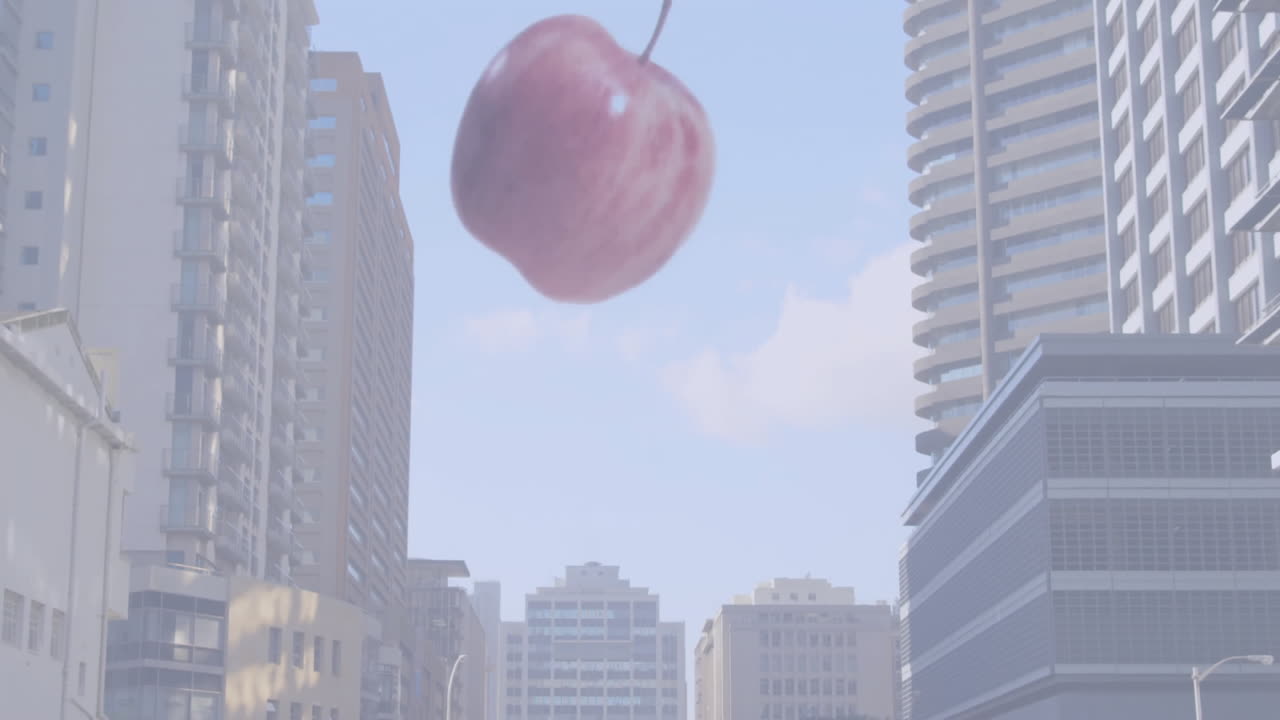 Large apple falling over cityscape with tall buildings and animation in sky