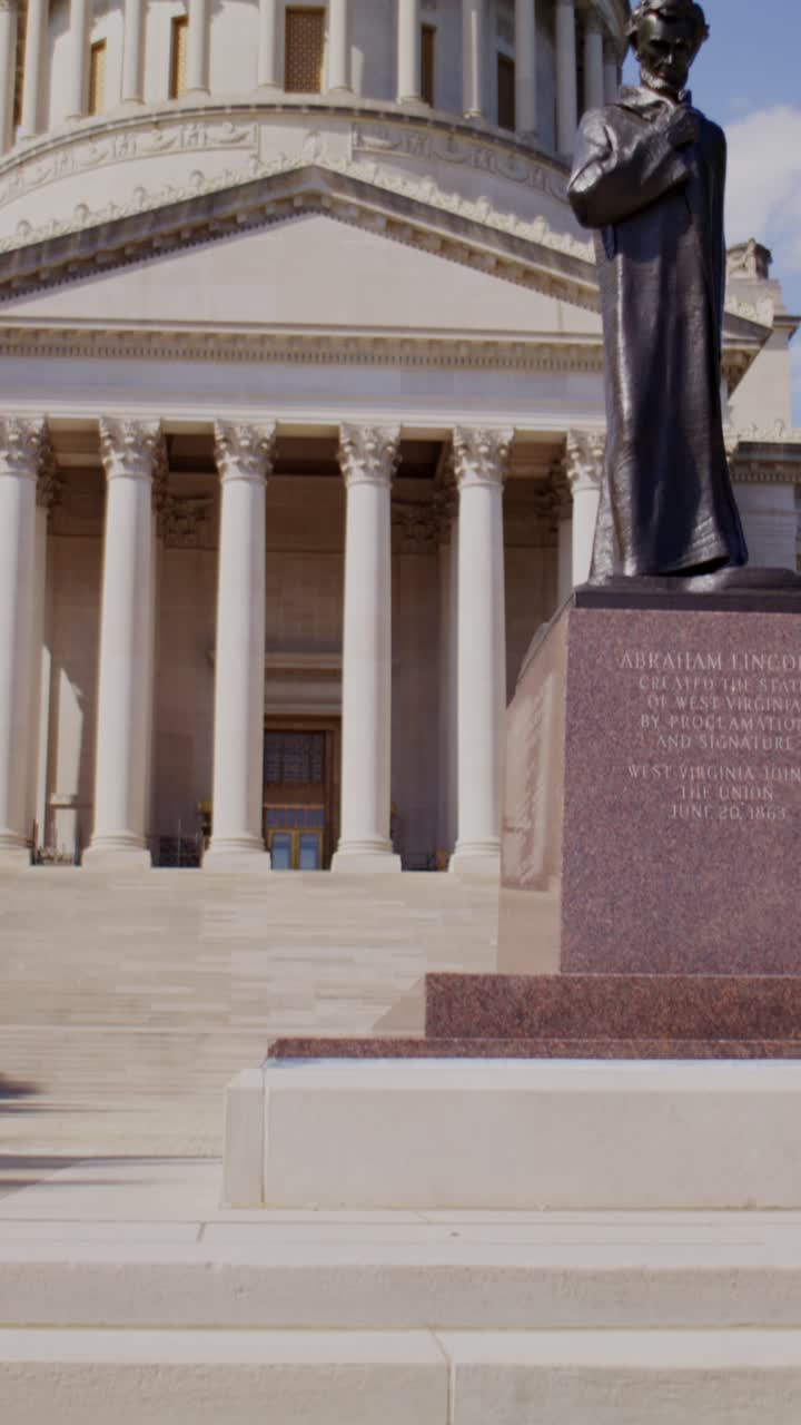 Ripresa cinematografica verticale in tilt-up dai gradini del Campidoglio che rivela la cupola del Campidoglio del West Virginia con movimento fluido stabilizzato e luce naturale.