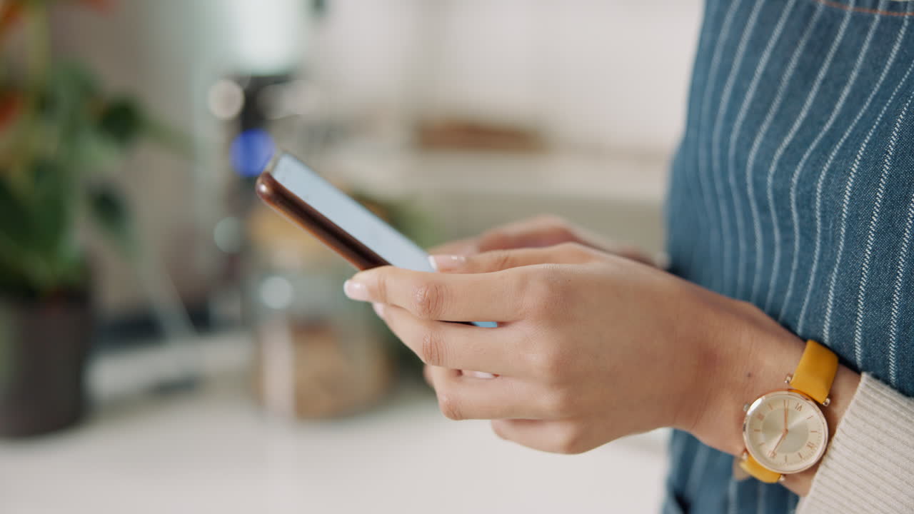 mujer usando teléfono móvil en la cocina