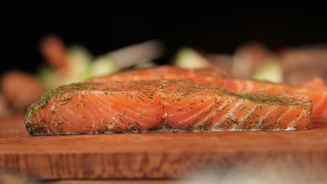 Toma-En-Cámara-Lenta-De-Un-Trozo-De-Salmón-Sobre-Una-Tabla-De-Madera-De-Cerca