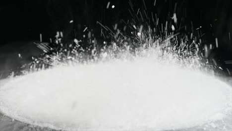 jumping flour on moving subwoofer on black background