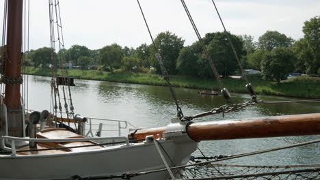 Hermoso-Barco-Antiguo-En-La-Costa-Y-Kayak-De-Remo-En-El-Fondo-Durante-El-Día-De-Verano,-Lübeck