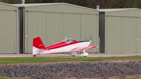 a red and white plane accelerates for takeoff