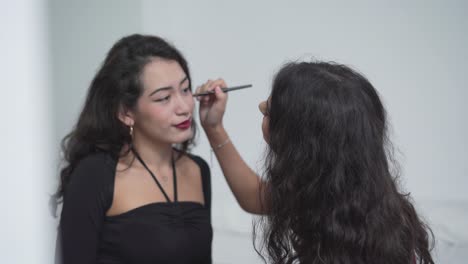 artista de maquillaje aplicando maquillaje a una mujer