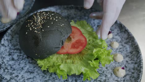 a professional chef is preparing a hamburger in his kitchen - 02