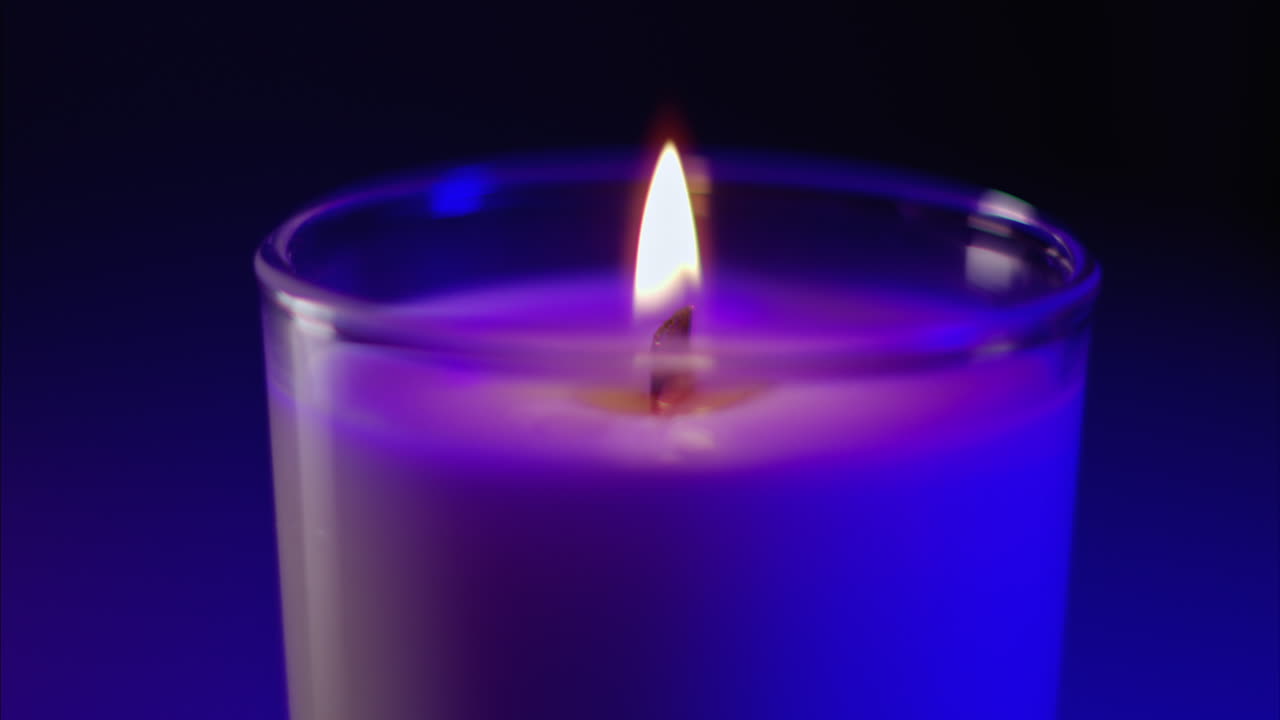 Candela profumata accesa con luce viola