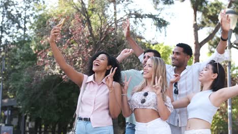 happy multiethnic friends taking self-portrait in city during sunny day