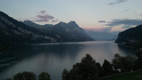 a magnificent view of walensee lake amidst mountain scenery and a pink-blue morning sky