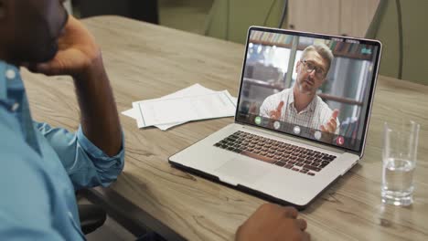 African-american-businessman-using-laptop-for-video-call-with-caucasian-business-colleague