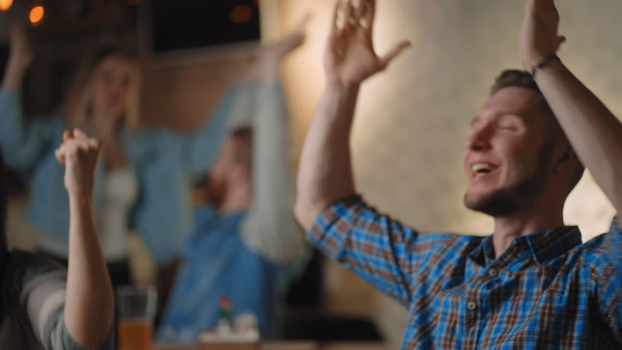 los fanáticos celebran la victoria. los partidarios apasionados gritan viendo el juego en la televisión. los fanáticos ven un partido de fútbol en un bar deportivo