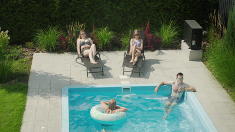 familia relajándose junto a la piscina, descansando bien en un caluroso día de verano