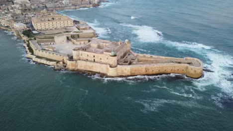 arco aéreo de un castillo en la punta de la isla de ortigia en el mar mediterráneo.