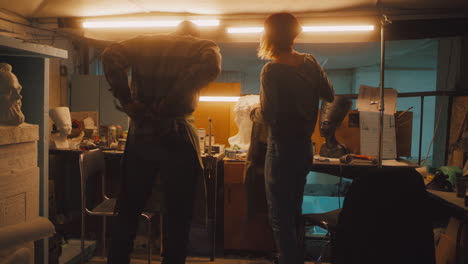 artists working in a sculpture studio with classical busts