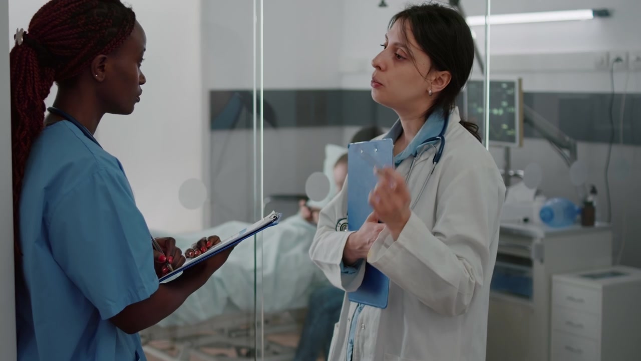 Doctor and Nurse Discussing Patient Medical Records in Hospital