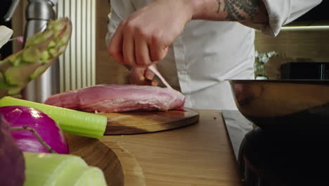 chef preparing meat with vegetables in kitchen