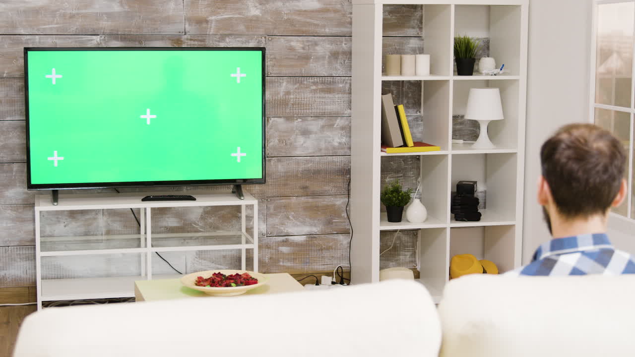 Living room with green screen television and white shelves