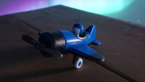 blue toy airplane on wooden table with colorful background