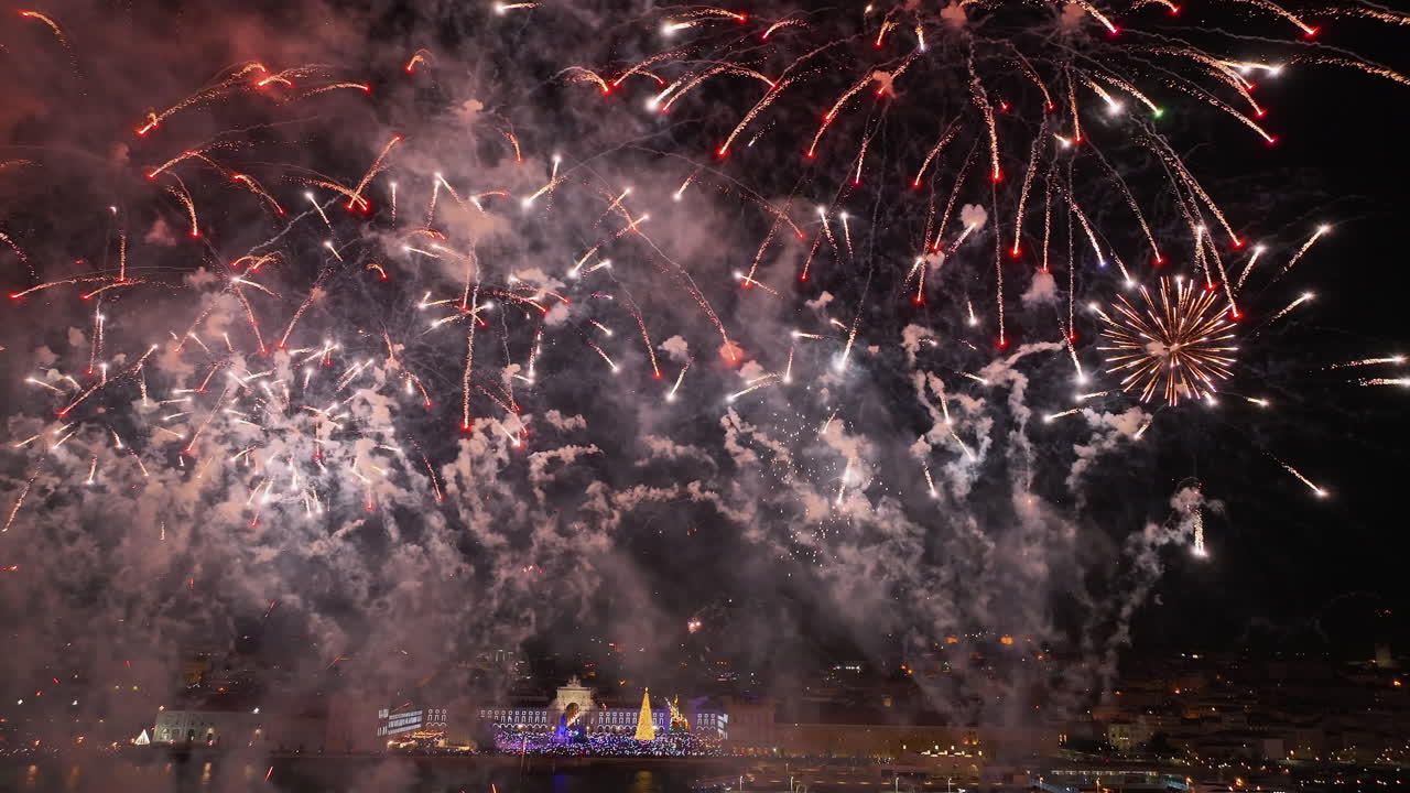 AERIAL: New Years eve fireworks on the Tagus river, night in downtown Lisbon