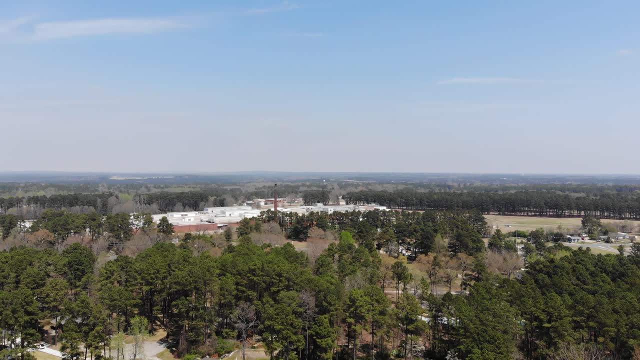 A flyover of Raeford North Carolina with Homes Trees and Factory off in the distance