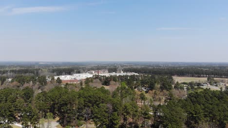 a flyover of raeford north carolina with homes trees and factory off in the distance