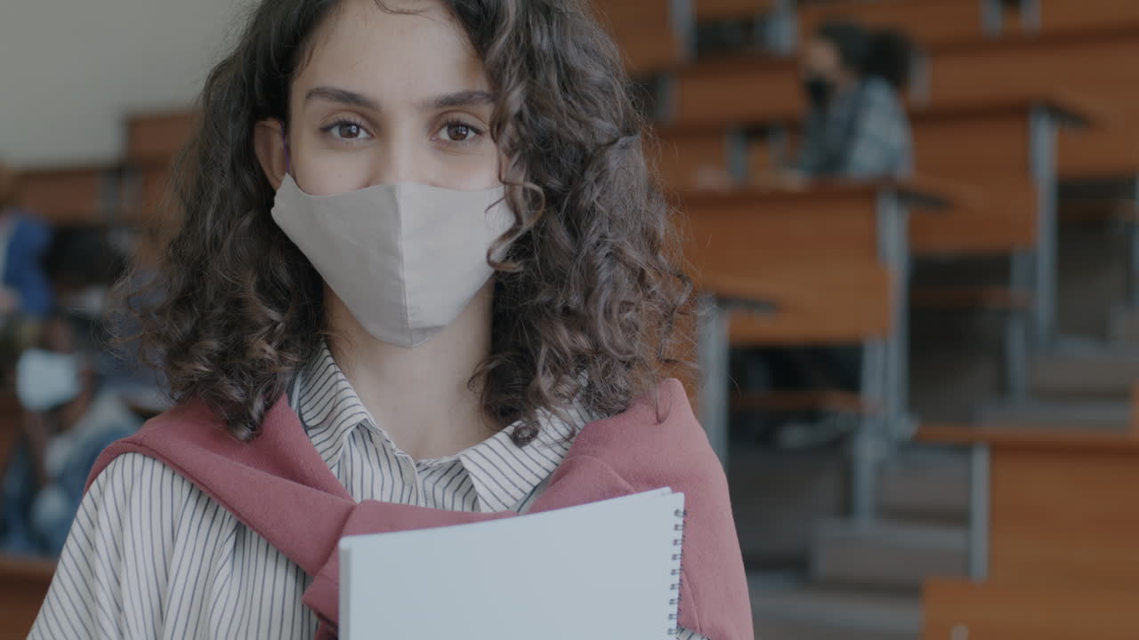 Student in a university classroom wearing a mask
