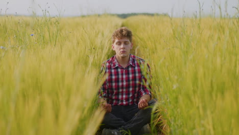 man meditating in a wheat field