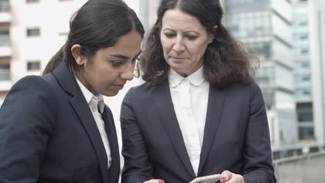 businesswomen using smartphone on street