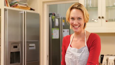 Smiling-woman-wearing-apron-spreading-dough-in-baking-tin-4K-4k