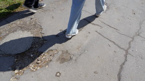 people walking on terrible condition asphalt sidewalk, city problems