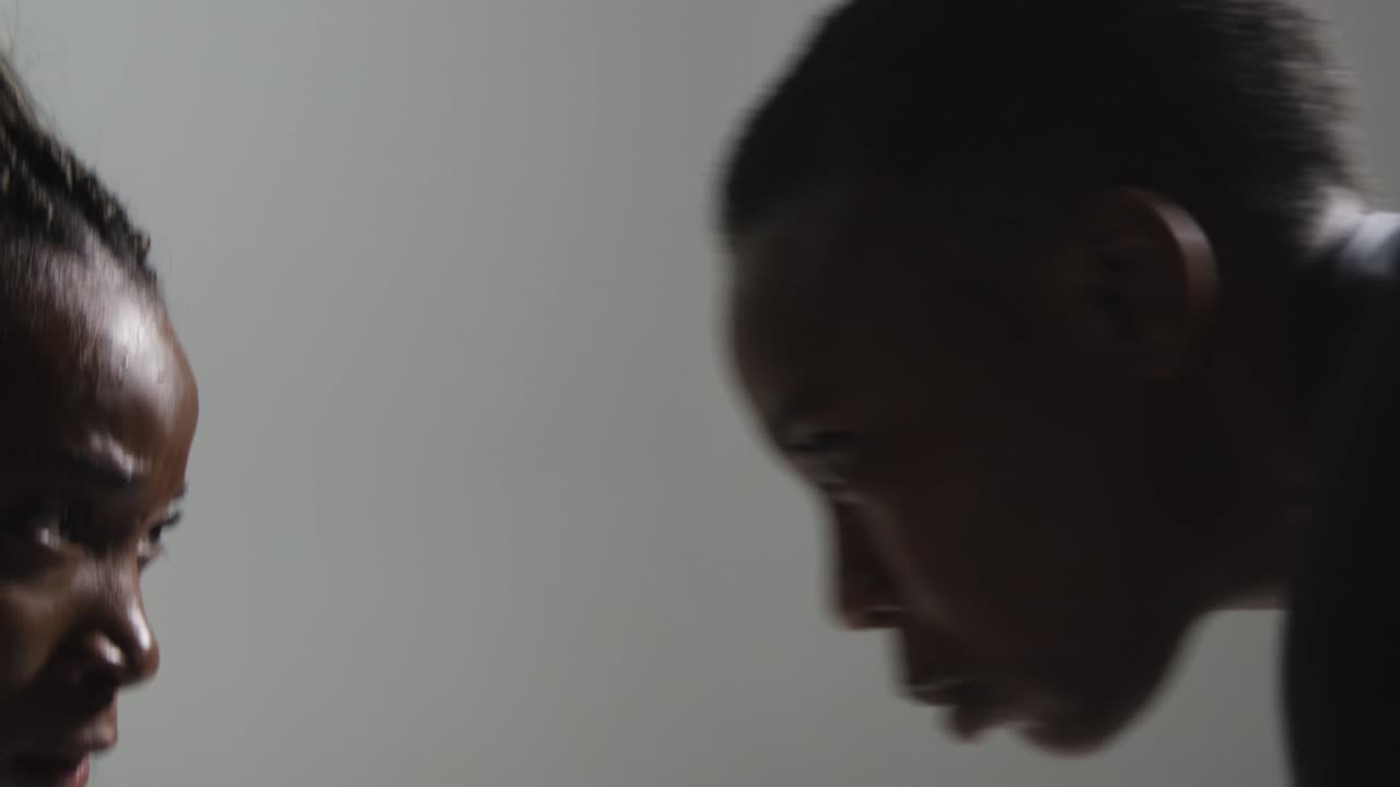 disparo de estudio de cerca de dos mujeres vestidas con ropa de gimnasia frente a frente haciendo ejercicio