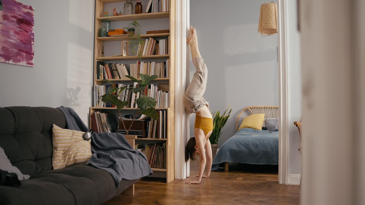 Woman doing a handstand in her living room