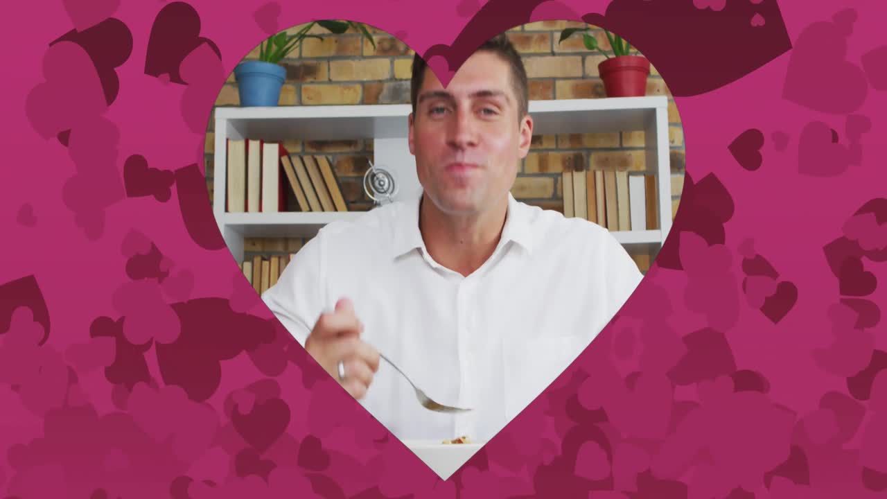 animación de un cuadro en forma de corazón sobre un hombre caucásico hablando y comiendo en una cita de video