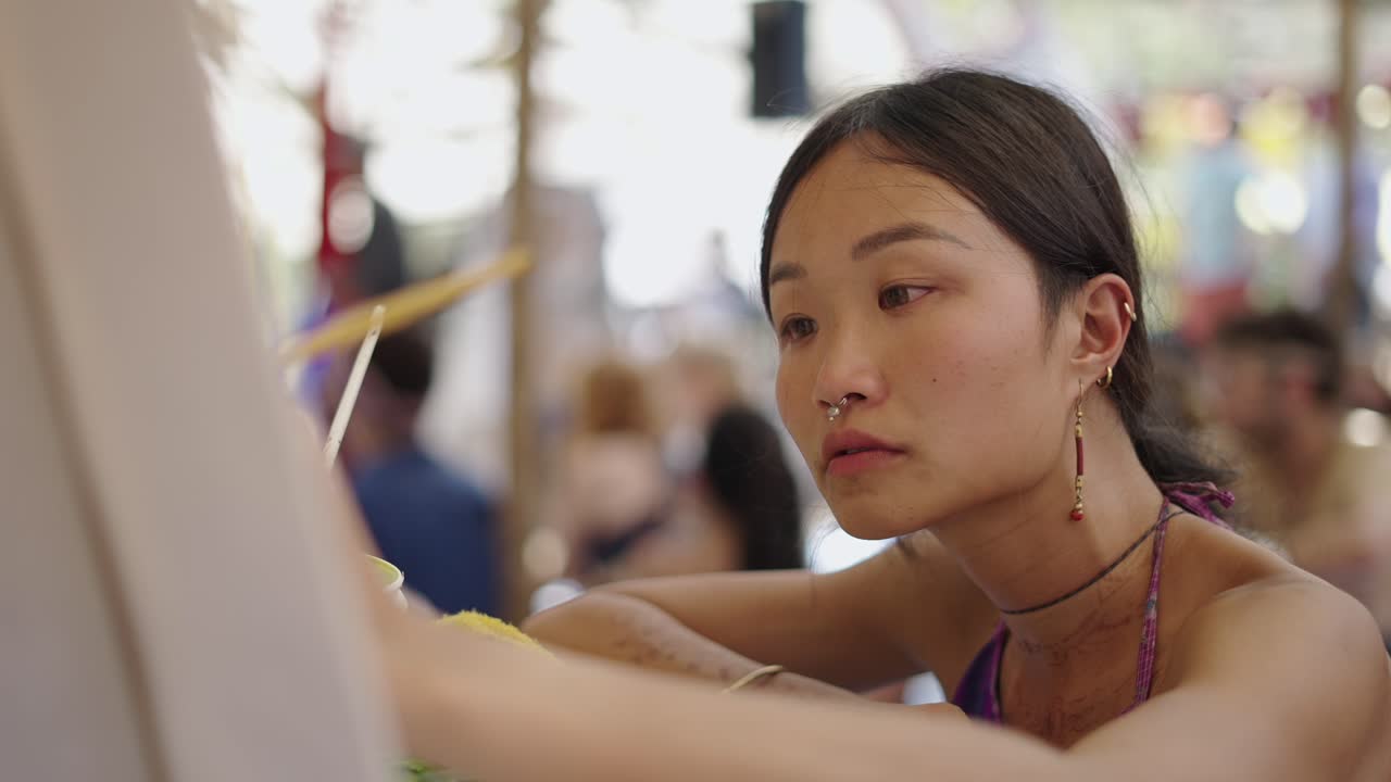 Young Woman Concentrates on Painting Outdoors
