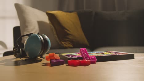 protectores para los oídos y rompecabezas de forma entrelazada en la mesa en casa para un niño diagnosticado con tea 1