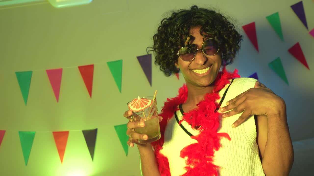 Man at a party with a cocktail and neon lights