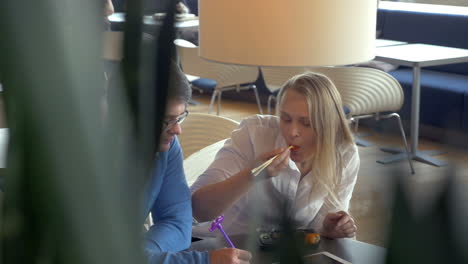 happy couple eating sushi at restaurant