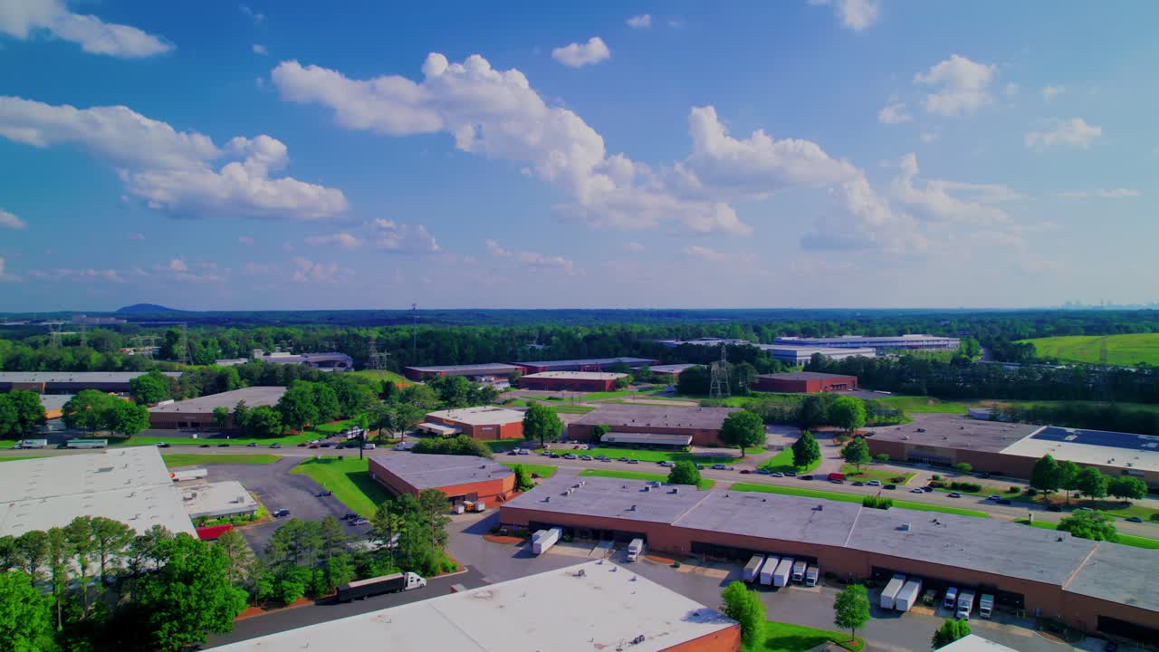 Busy Norcross, Georgia logistics hub, showing warehouses, loading docks with trucks, and the daily commercial activity in this industrial estate.