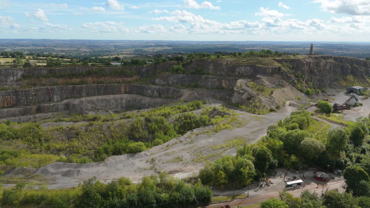 Drone footage of quarry site and surrounding countryside near Crich with rugged terrain, open pit, and green rolling hills, UK