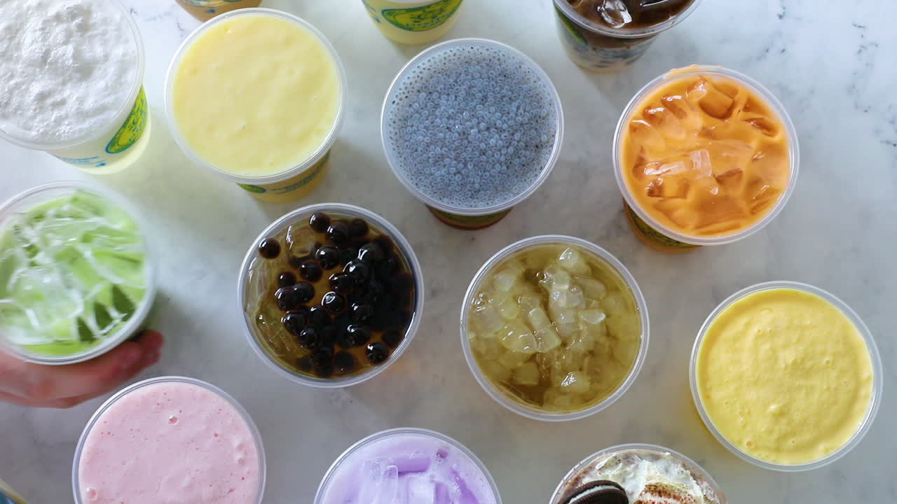 평평한 배열에서 녹색 마차 밀크티를 밀어내는 남성 손