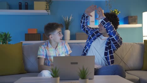 dos hermanos pequeños viendo un partido de fútbol en la computadora portátil.