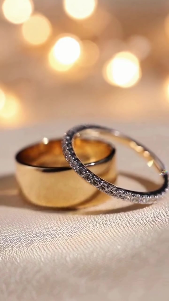Primo piano di eleganti fedi nuziali d'oro su tessuto di raso