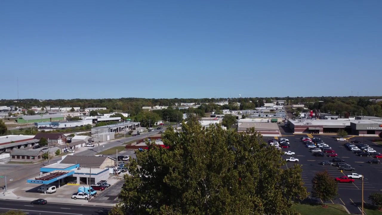 Filmato drone che si alza sopra una proprietà storica della Route 66 a Springfield, Missouri, rivelando attività commerciali vicine, il traffico e il paesaggio urbano circostante