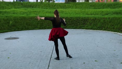 full body from the back view at female dancer dancing in the park