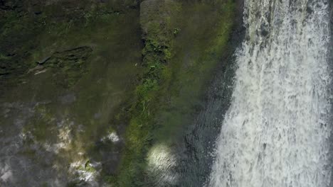 peaceful woodland forest splashing waterfall slow motion flowing paradise wilderness closeup rising tilt up