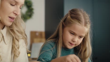 Tracking-video-of-caucasian-mother-and-daughter-preparing-dried-fruits-for-Christmas-decorations.