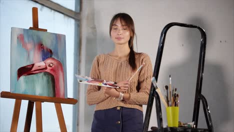 woman artist painting a flamingo
